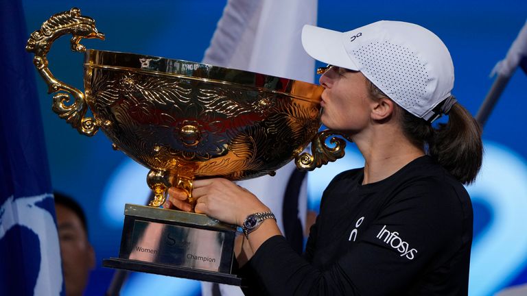 Iga Swiatek  kisses her trophy on stage after winning the China Open